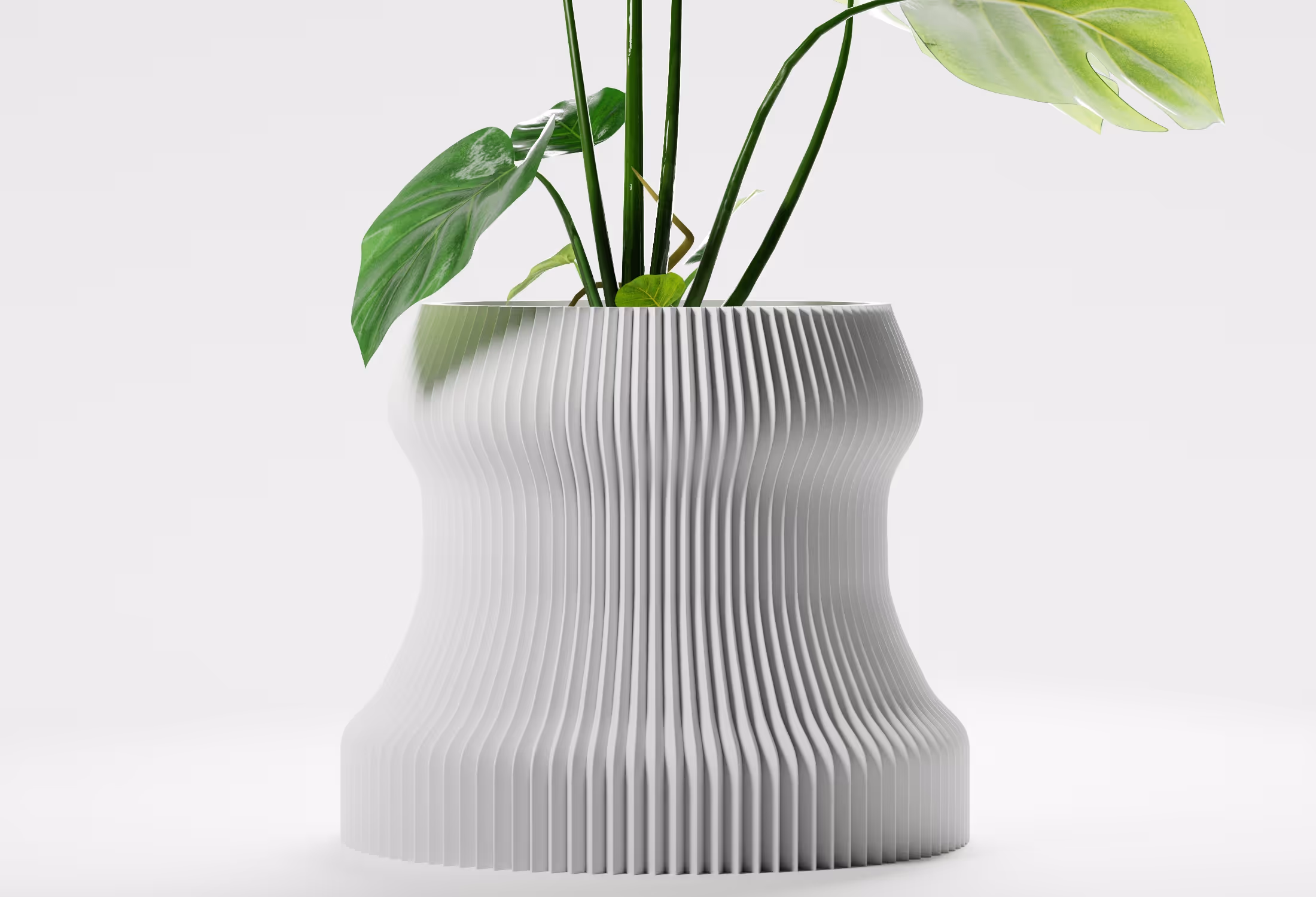 White modern planter with vertical ridges holding green leafy plants on a light background.
