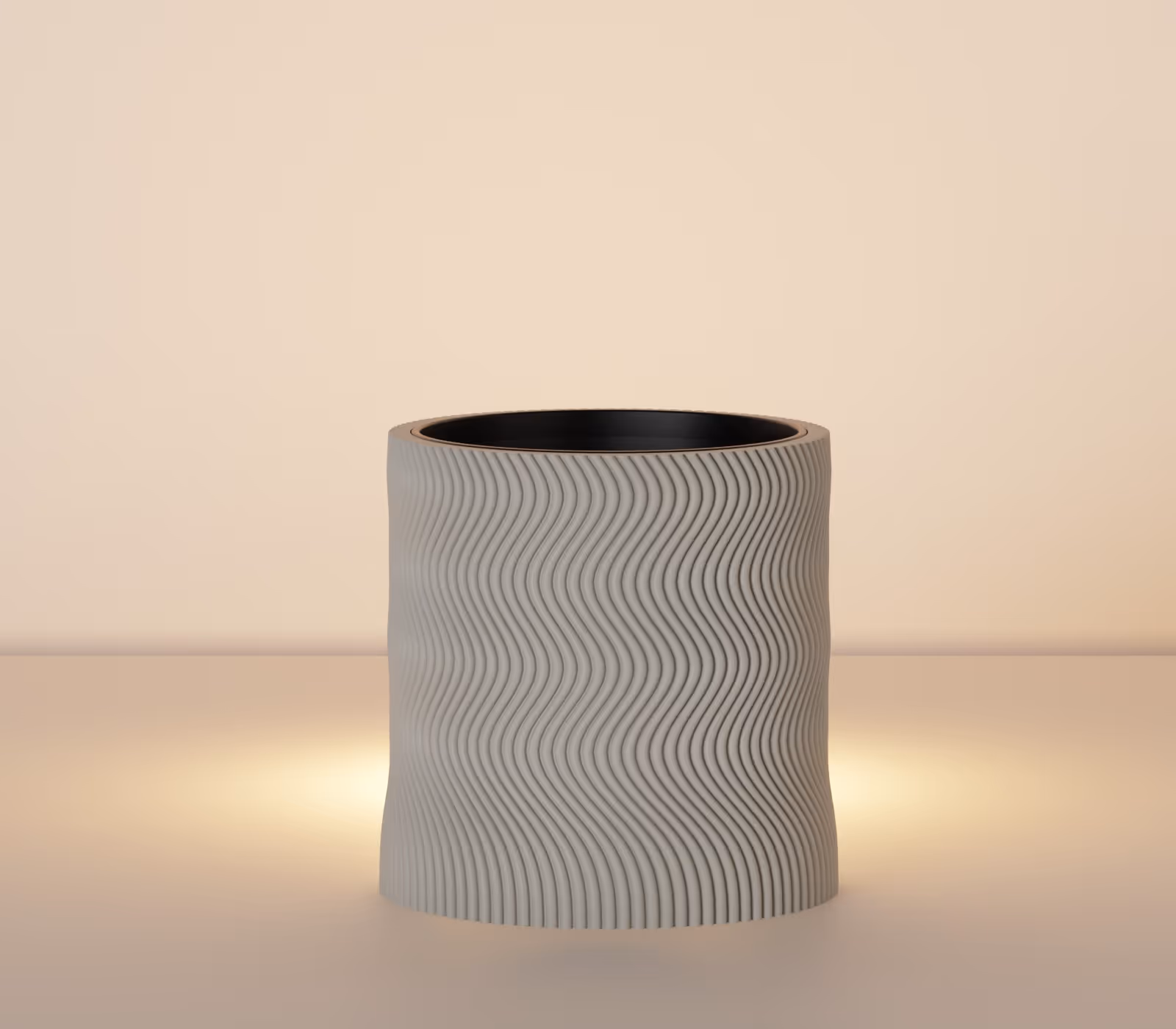 Gray cylindrical pot with wavy vertical ridges on a beige surface with soft light behind it.
