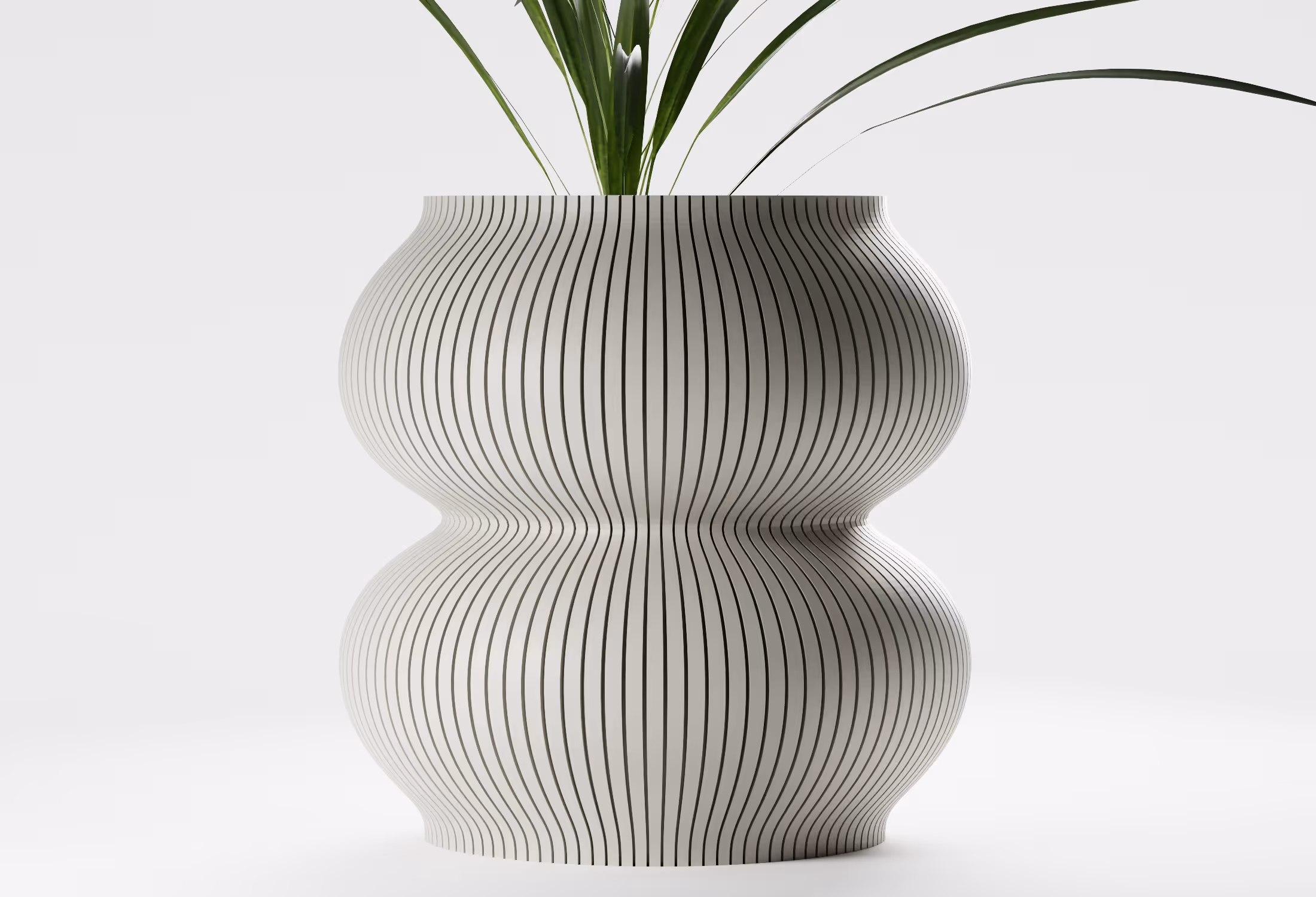 Modern white vase with vertical black stripes and curvy shape holding green plant leaves.
