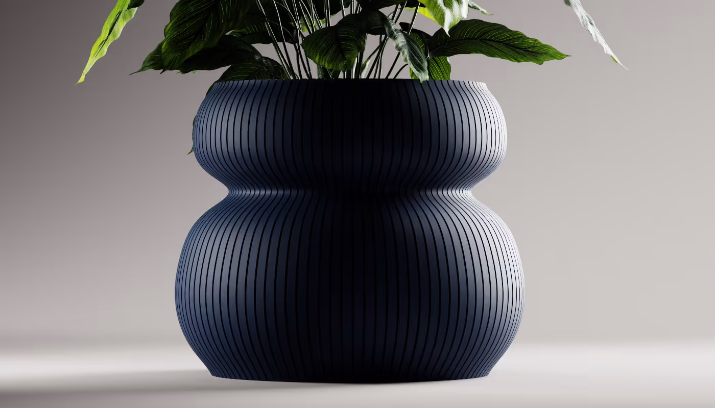 Curvy dark blue ribbed planter pot with green leafy plant on a light background.