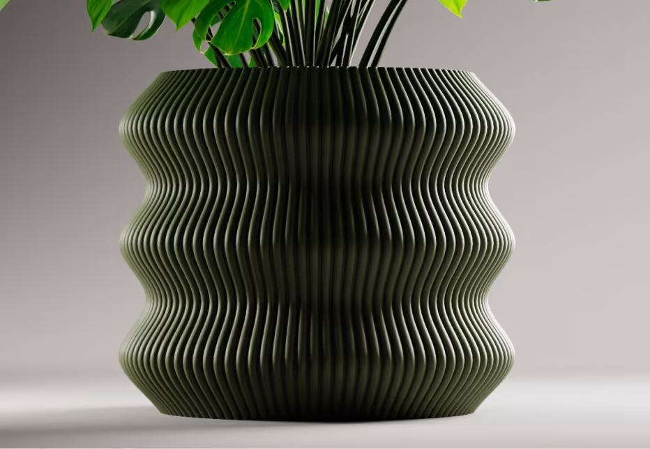 Dark green ribbed ceramic planter with wavy pattern holding green leafy plants on a gray surface.