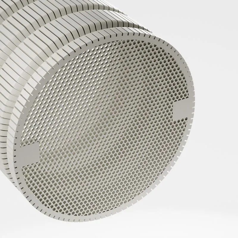Close-up of the end of a cylindrical object with a honeycomb-like perforated surface and concentric ribbed rings.